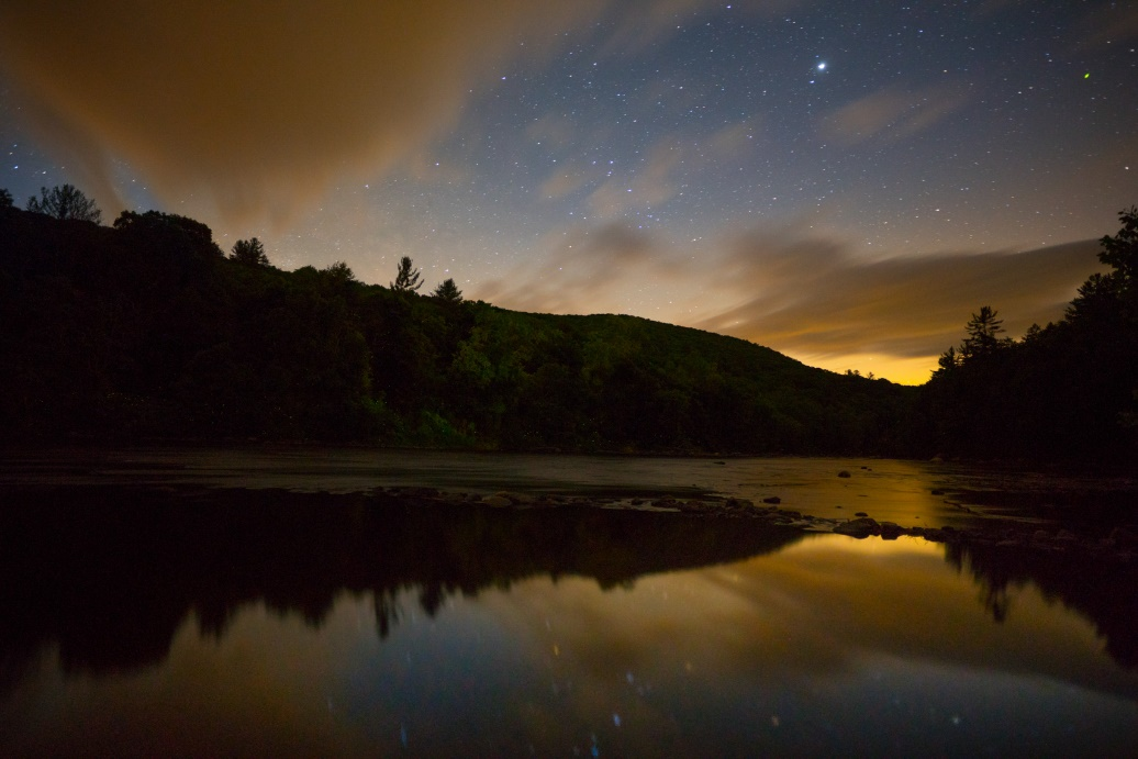 A landscape shot of a lake and the night sky.